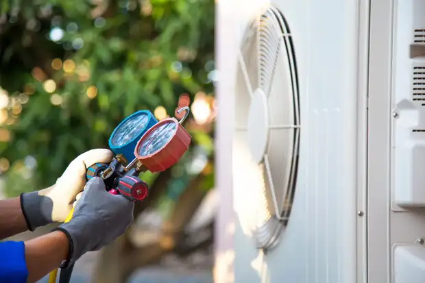 Manifold gauges connected to an air conditioner during an A/C clean and check
