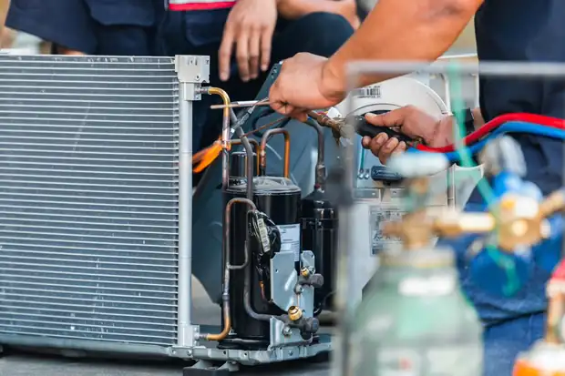 Open air conditioning condenser with compressor and refrigerant lines exposed during a repair